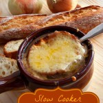 A bowl of steaming Slow Cooker French Onion Soup with a slice of crusty french bread and melted cheese on top.