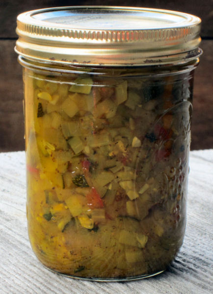 A jar of homemade zucchini relish cooling after being processed by the water bath canning method.