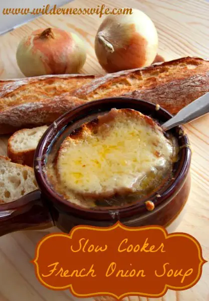 A bowl of steaming Slow Cooker French Onion Soup with a slice of crusty french bread and melted cheese on top.