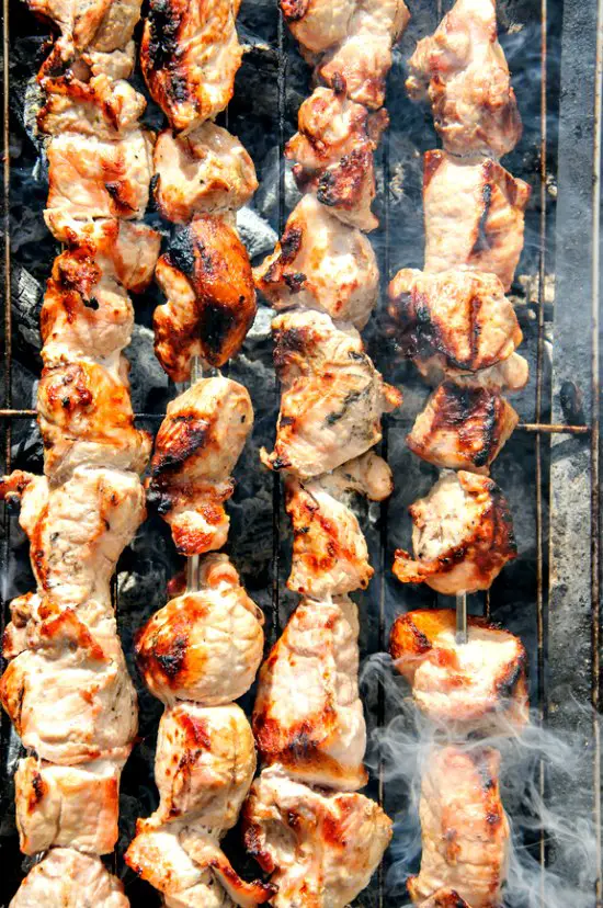 Chicken shish kebabs grilling on a gas grill.