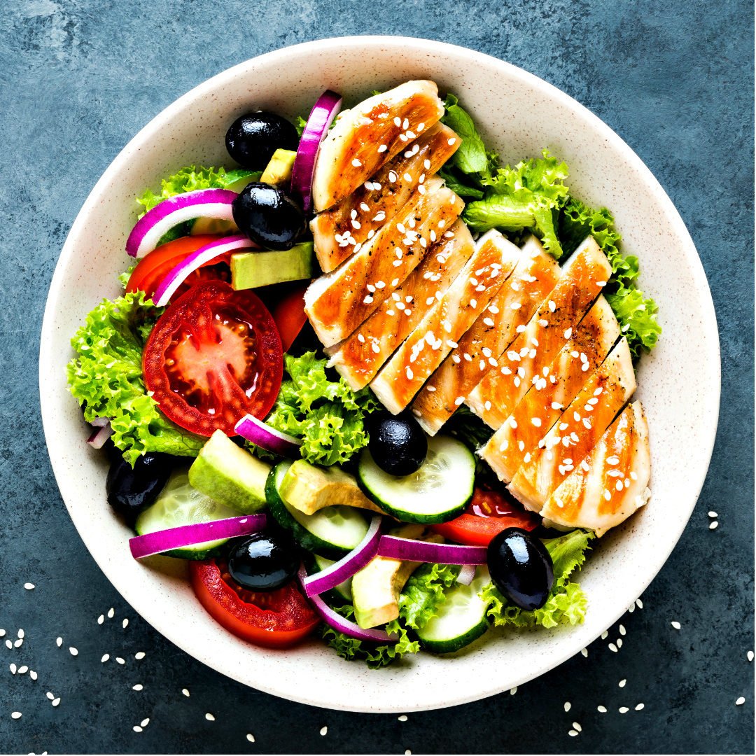 Marinated grilled chicken breaston a summer green salad