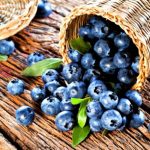 Maine Blueberries in an overturned basket on wood table
