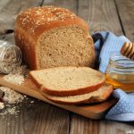 Honey Oatmeal bread loaf with jar of honey and oatmeal