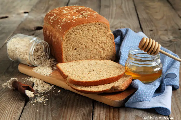 Honey Oatmeal bread loaf with jar of honey and oatmeal