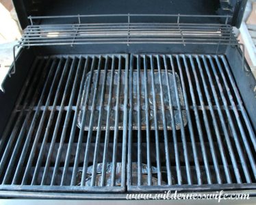 Gas Grill with pan of green apple wood in the front and a water pan in the back ready to smoke our baby back pork ribs. 