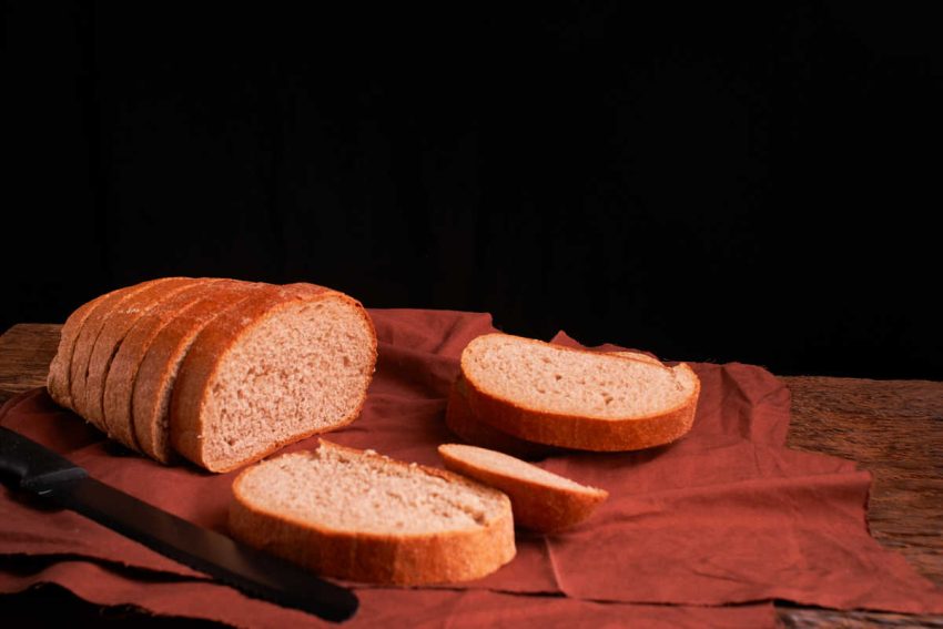 KitchenAid Wheat Bread Recipe loaf sliced on wooden cutting board