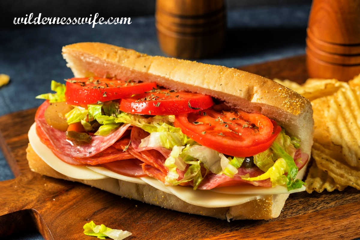 Italian grinder 
 Italian sandwich on a dark wood cutting board after being slathered with Italian Salad Dressing