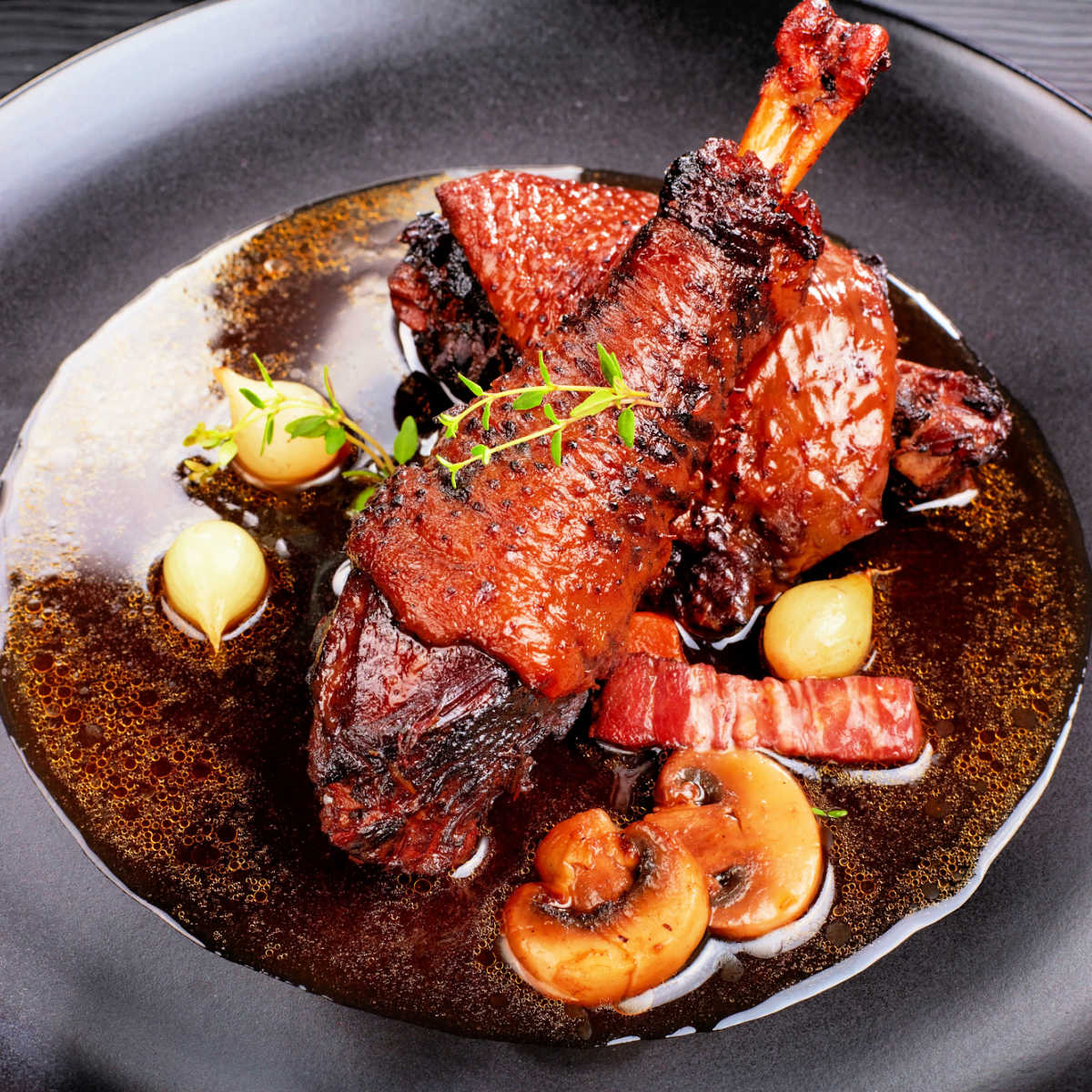 black clay bowl of mouth-watering coq au vin