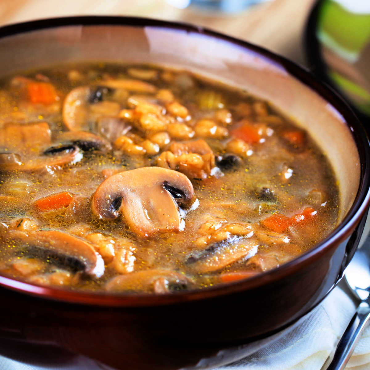 close-up photo of a bowl of steaming mushroom barley soup
