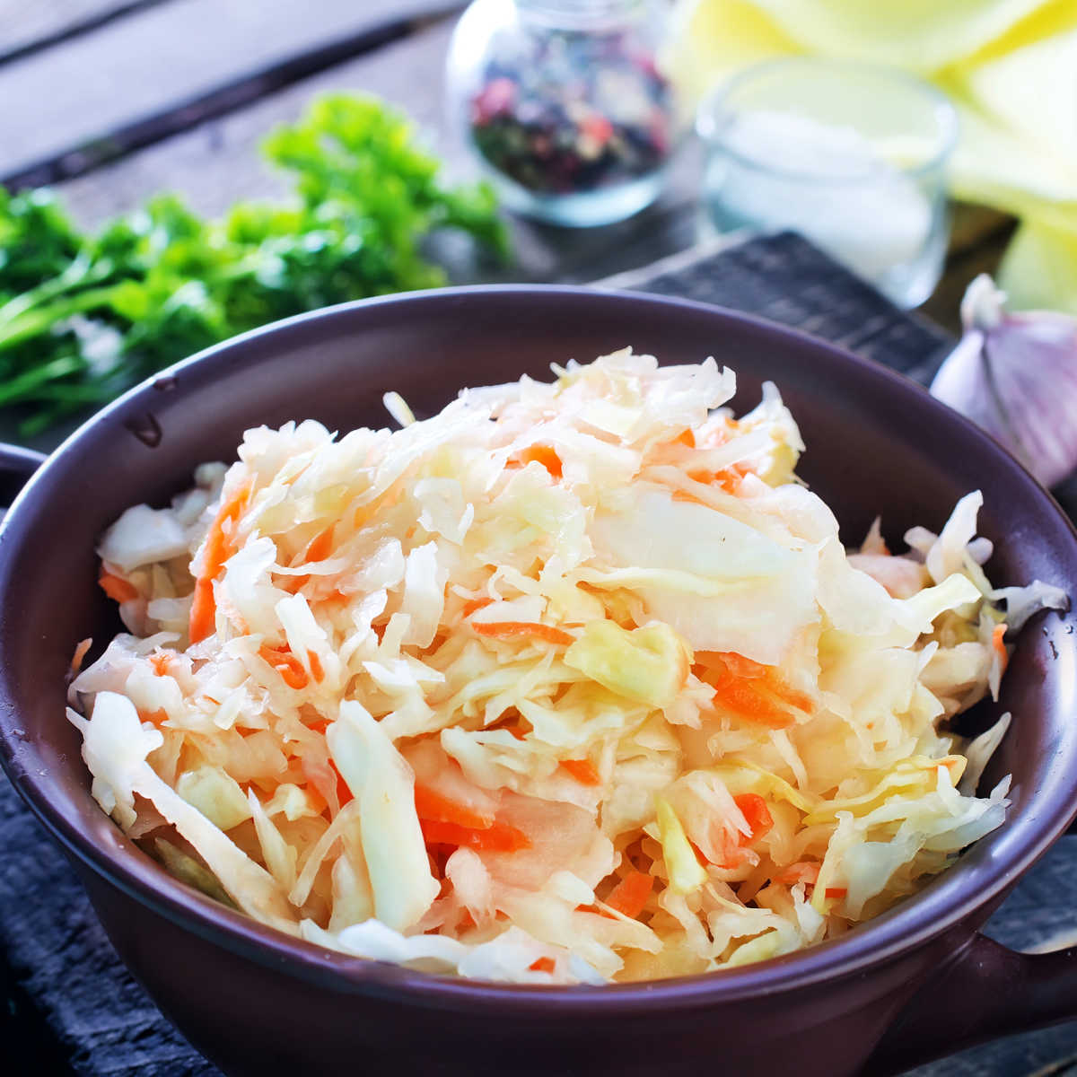 black bowl filled with coleslaw sitting on a dlue napkin